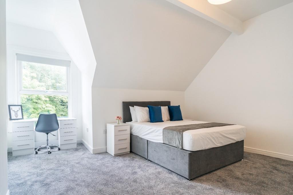 Spacious double bedroom featuring a comfortable...