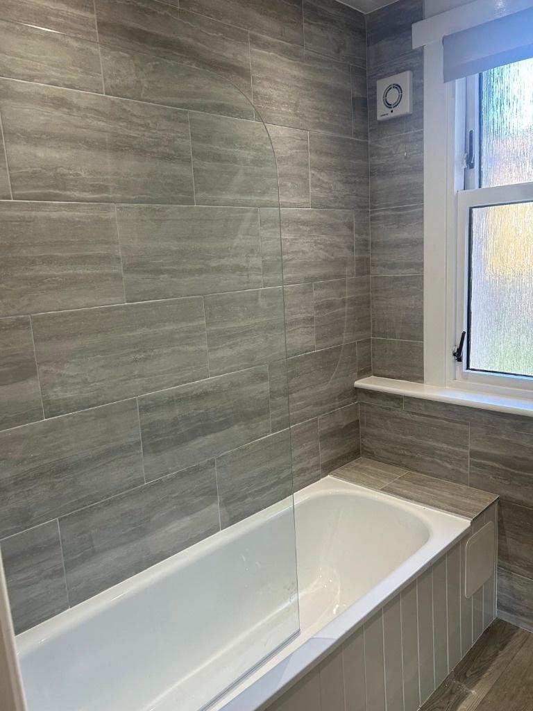 A modern bathroom featuring a large bathtub wit...