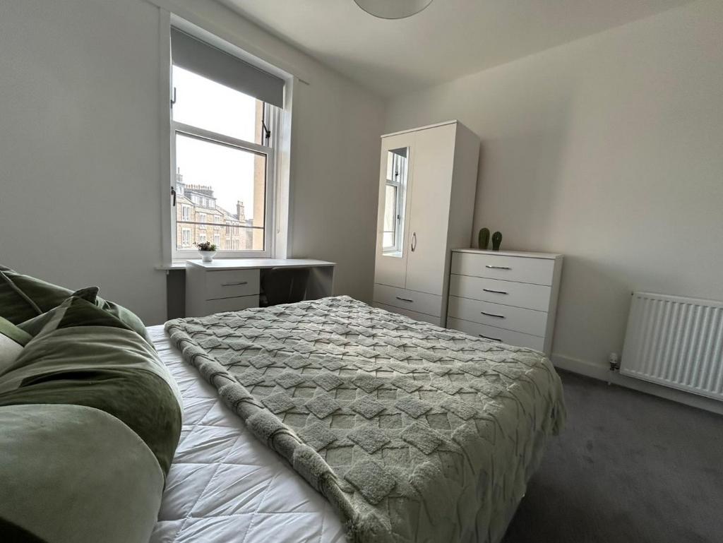 A bright, well-maintained bedroom with a comfor...