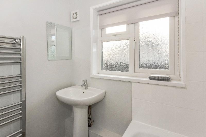 Bright and tidy bathroom featuring modern fixtu...