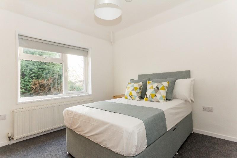 This inviting double bedroom features a cozy at...