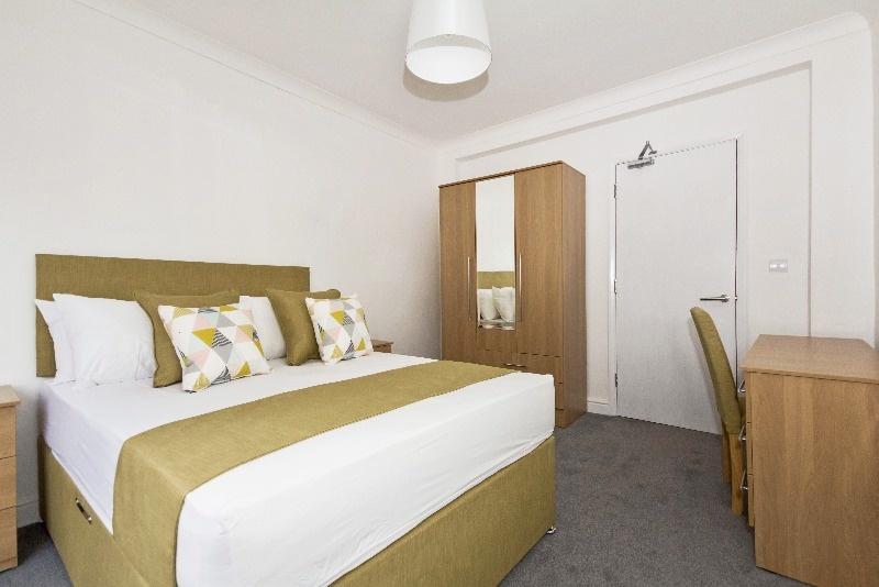A cozy double bedroom featuring a stylish bed w...