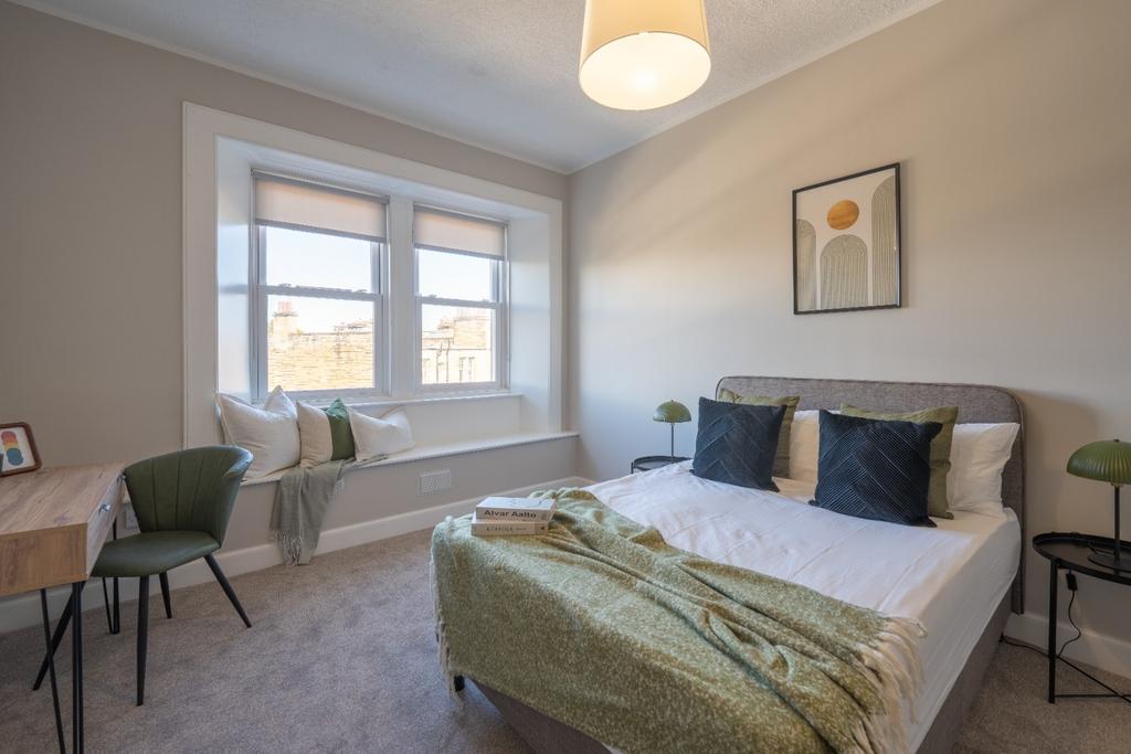 This cozy double bedroom features a comfortable...