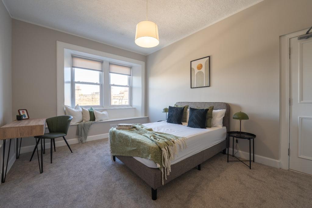 This inviting double bedroom features ample nat...