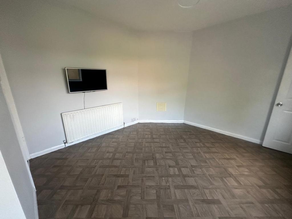 A spacious living room featuring neutral grey w...