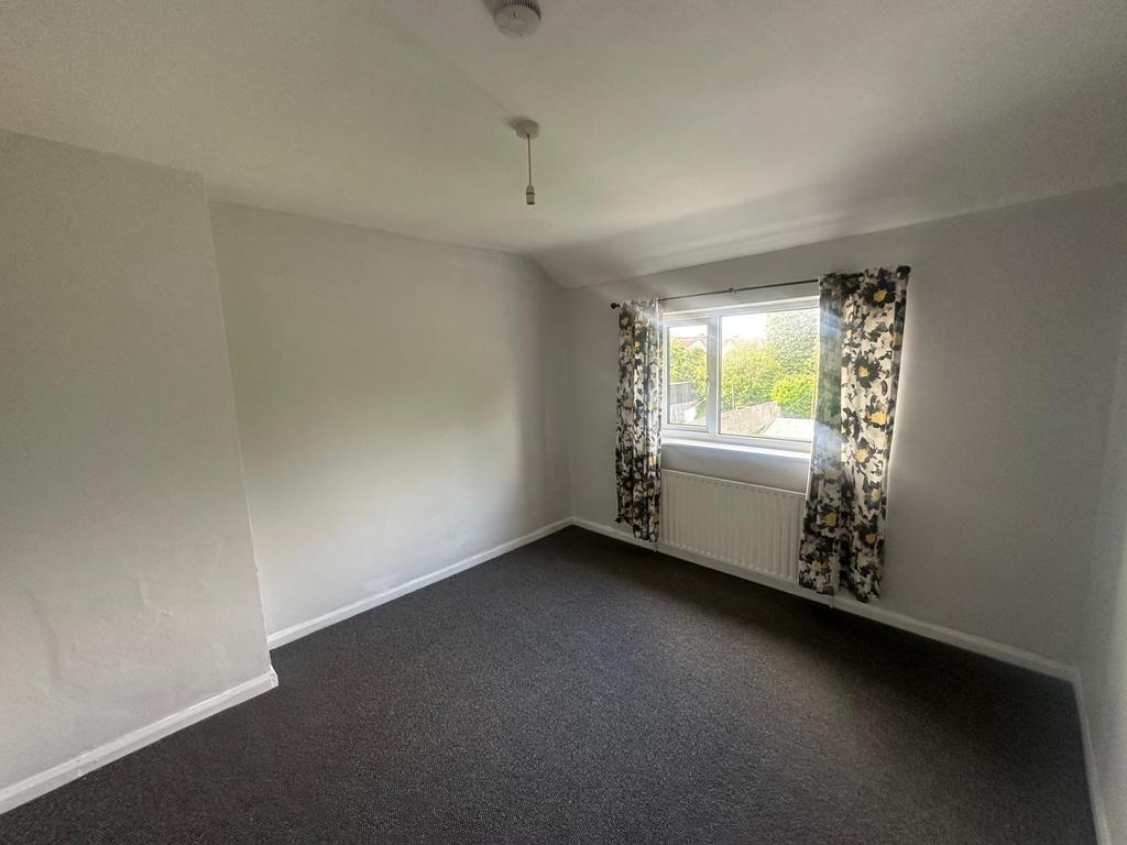 A bright double bedroom featuring a large windo...