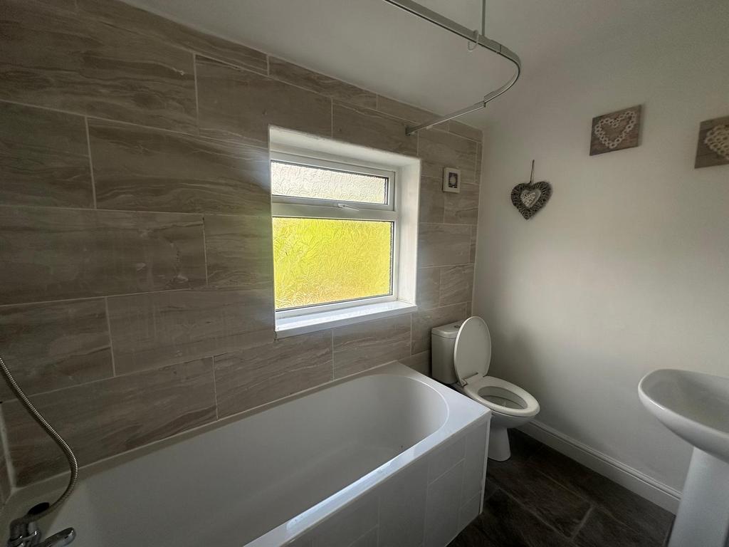 Bright and clean bathroom suite featuring a mod...