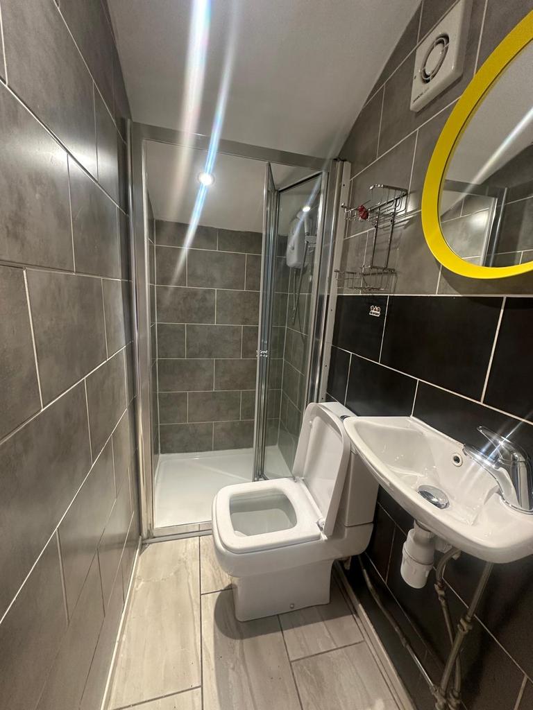 A modern bathroom featuring a tiled shower encl...