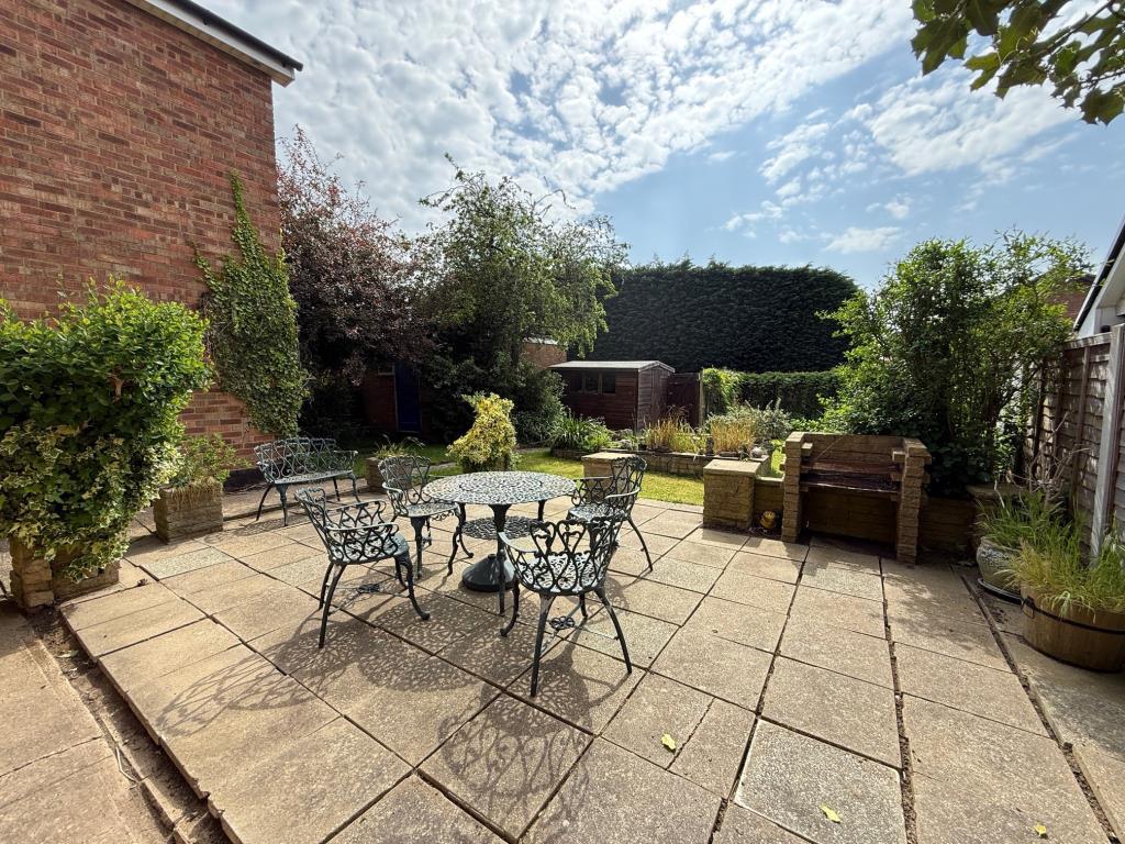 Patio area with pathway leading to lawn, shed, gar
