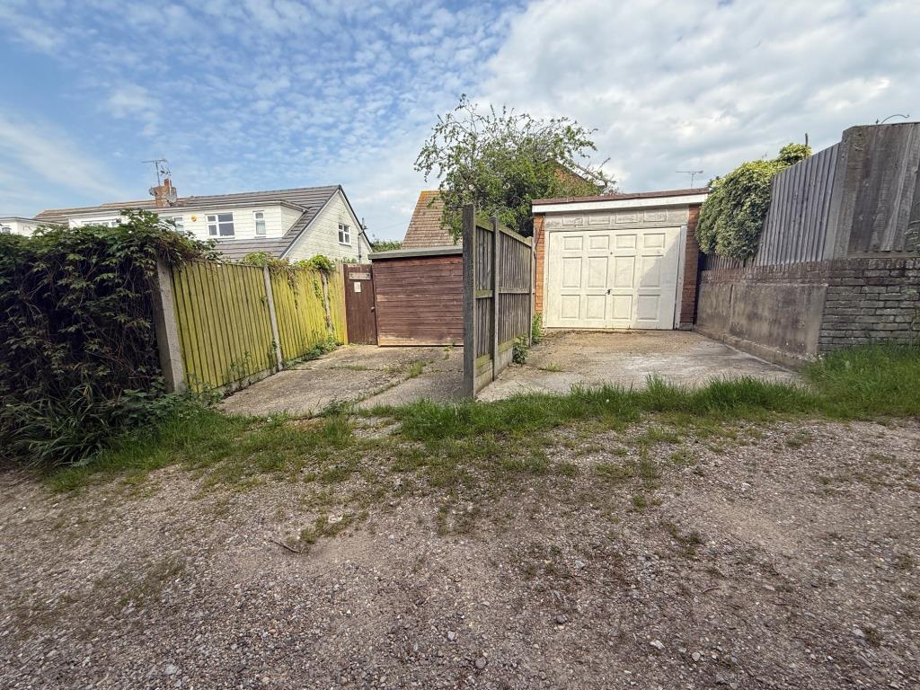 Garage with up and over door and space in front pl