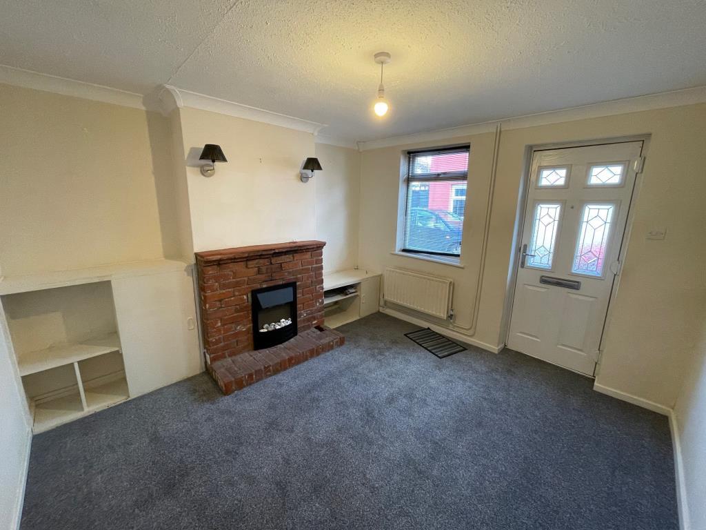 Living room with front door, window and fireplace