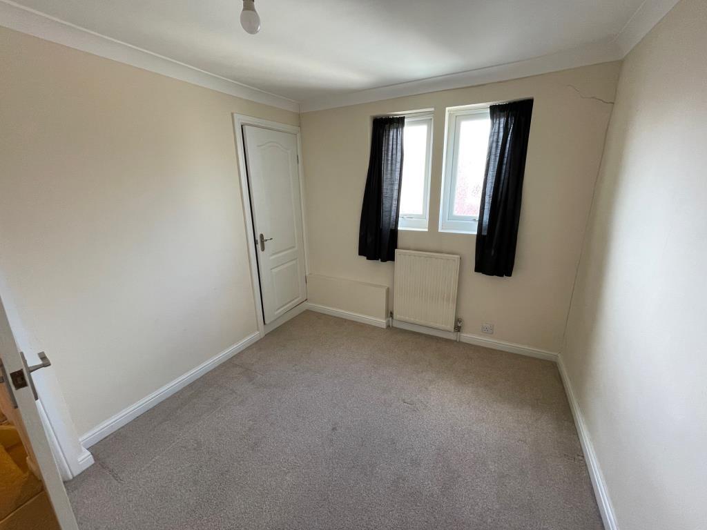 Bedroom 2 with cupboard and two windows to the rea