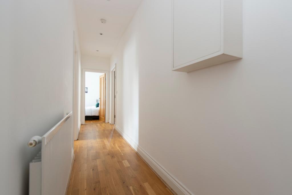 A bright and tidy hallway with modern decor, le...