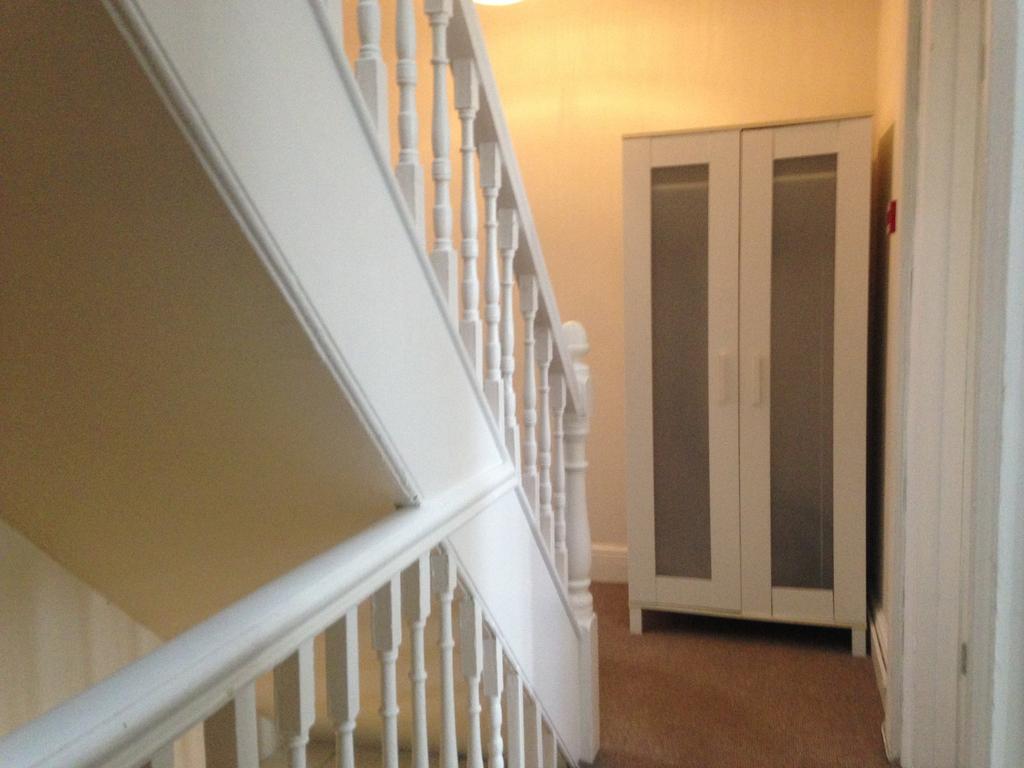 A well-lit and tidy staircase leading to upper ...