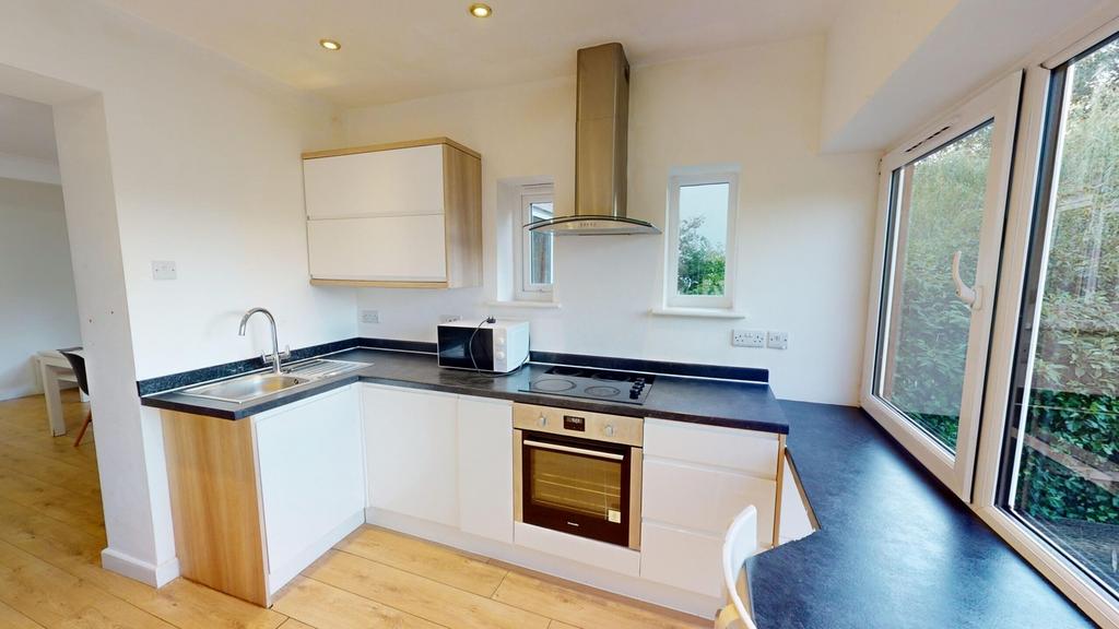 A bright and modern kitchenette with ample natu...