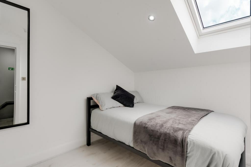 A cozy single bedroom featuring a comfortable b...