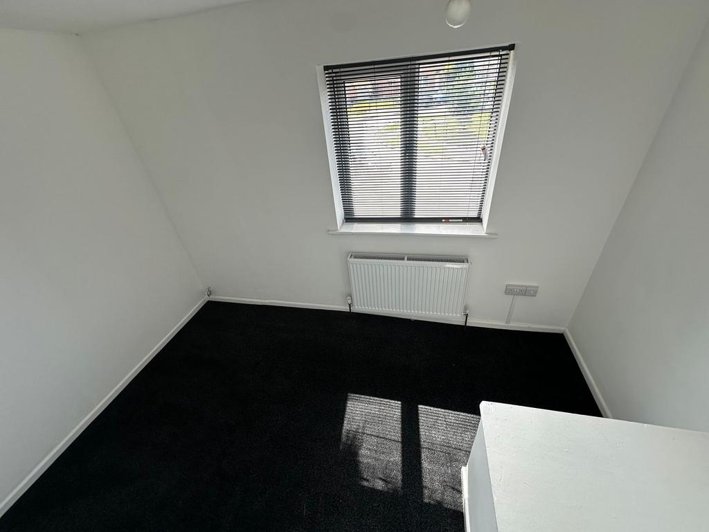 A small, clean room with a window fitted with b...