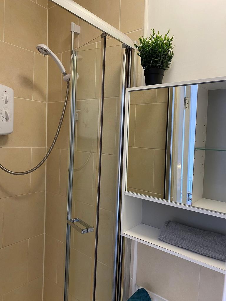 This modern bathroom features a sleek glass sho...