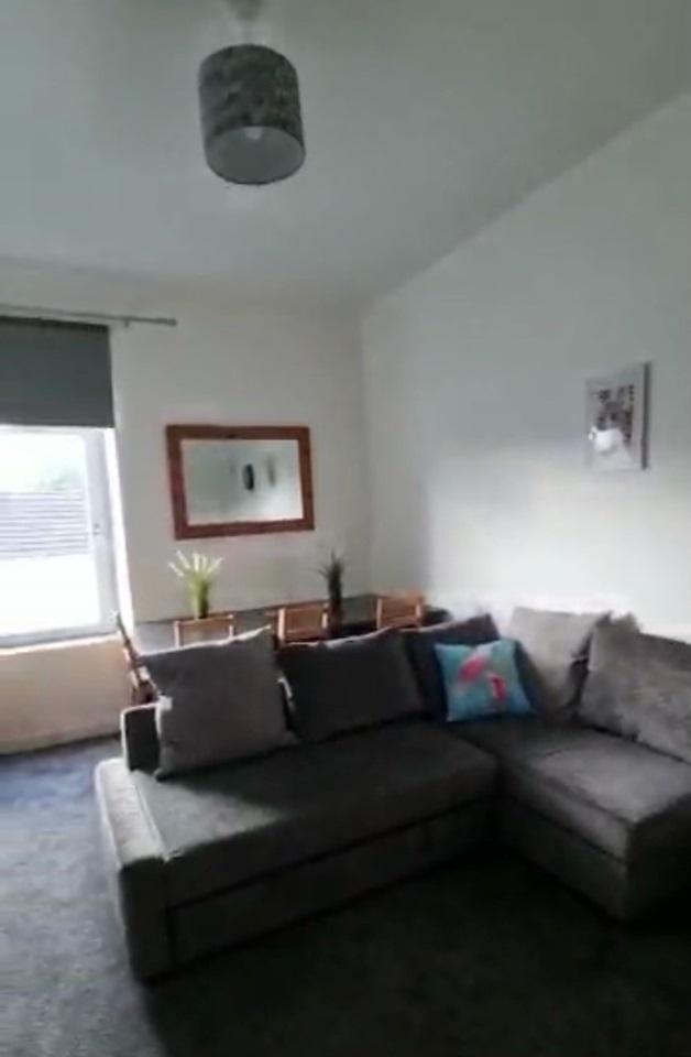 Bright living room featuring a comfortable grey...