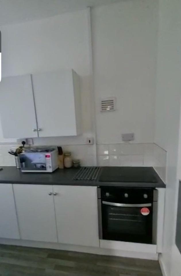 A neat and functional kitchen featuring white c...