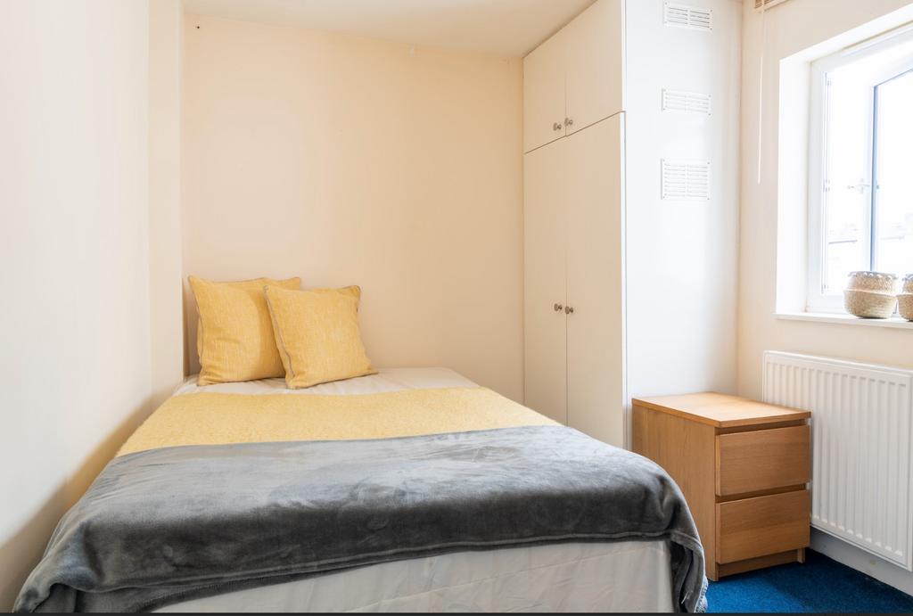 Cozy double bedroom featuring warm tones and am...