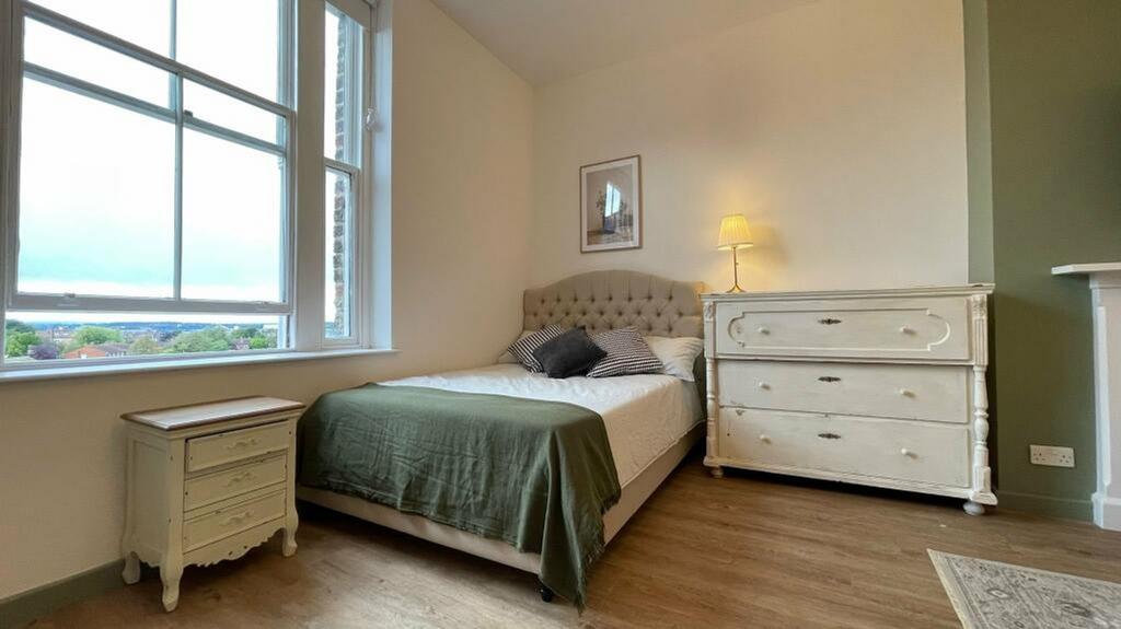 A bright and inviting double bedroom with styli...