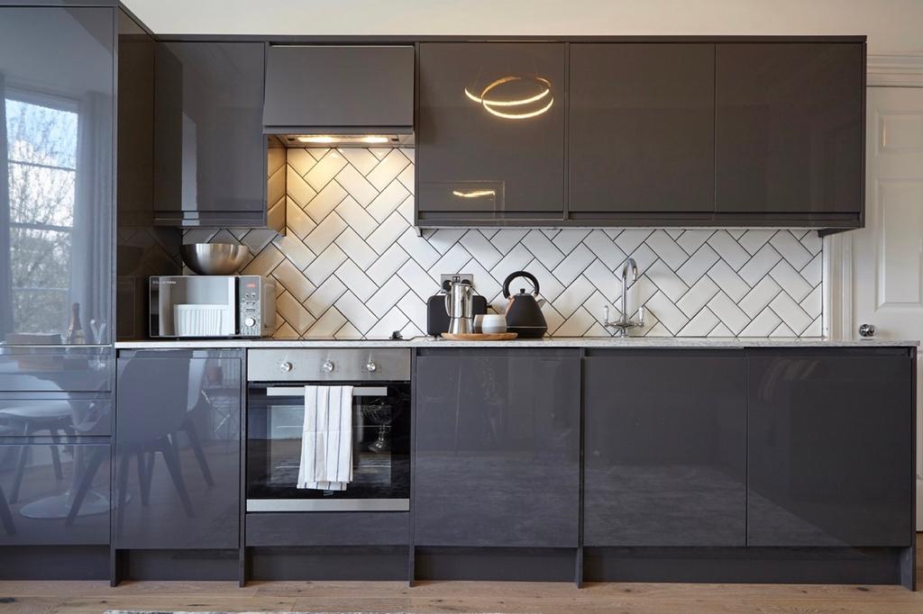 A modern and clean kitchen featuring sleek grey...