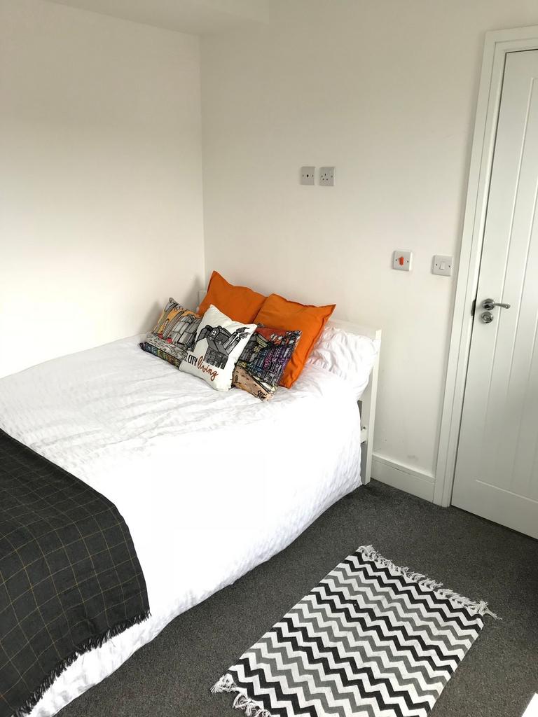 This cozy double bedroom features a comfortable...