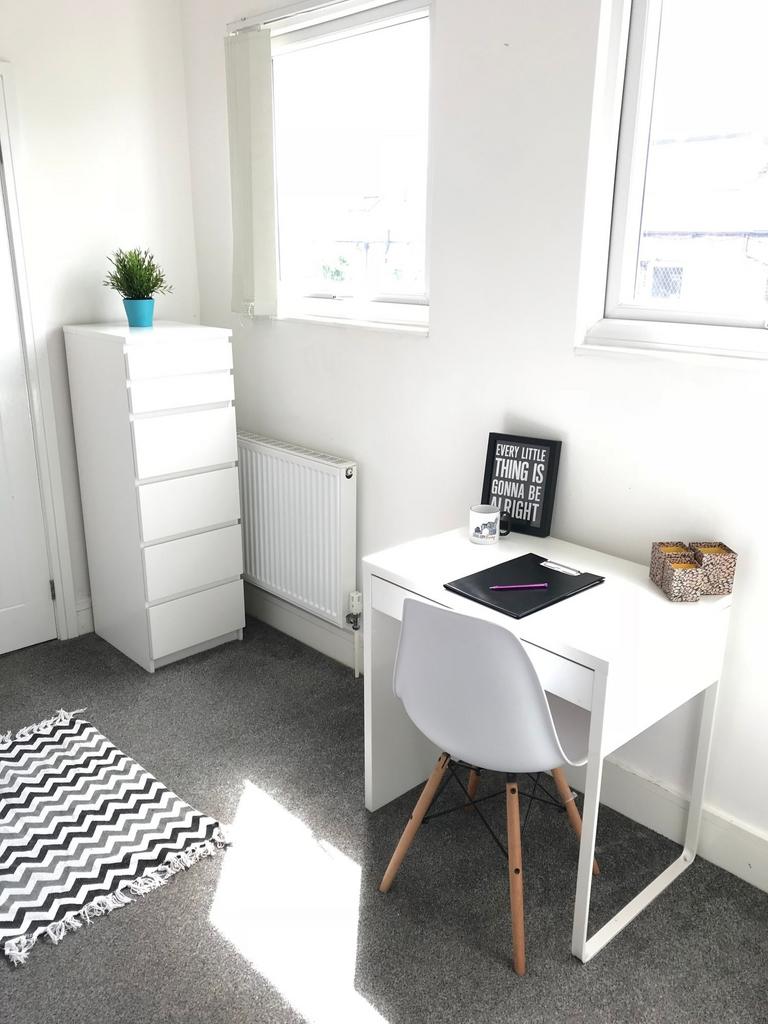 Bright and inviting communal workspace featurin...