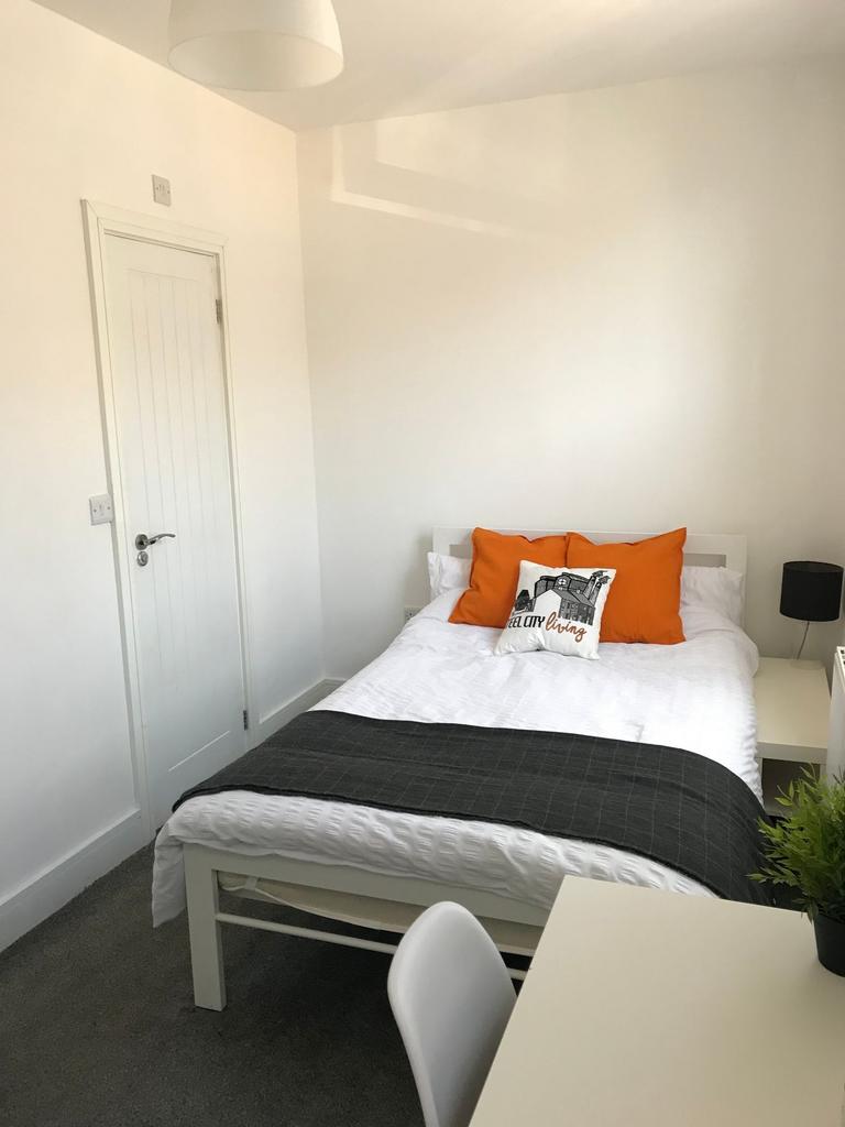 This cozy double bedroom features a comfortable...