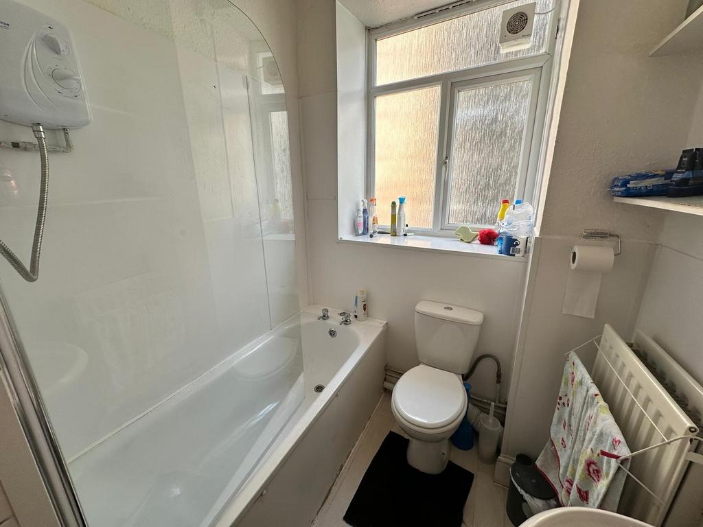 A bright and tidy bathroom featuring a bathtub ...