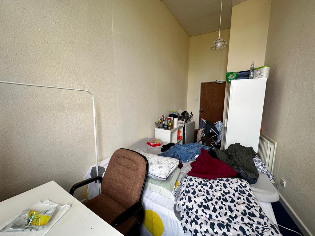 A spacious double bedroom with natural light an...