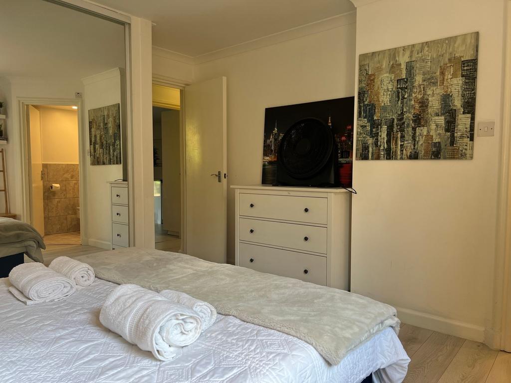 Spacious and tidy master bedroom featuring a co...
