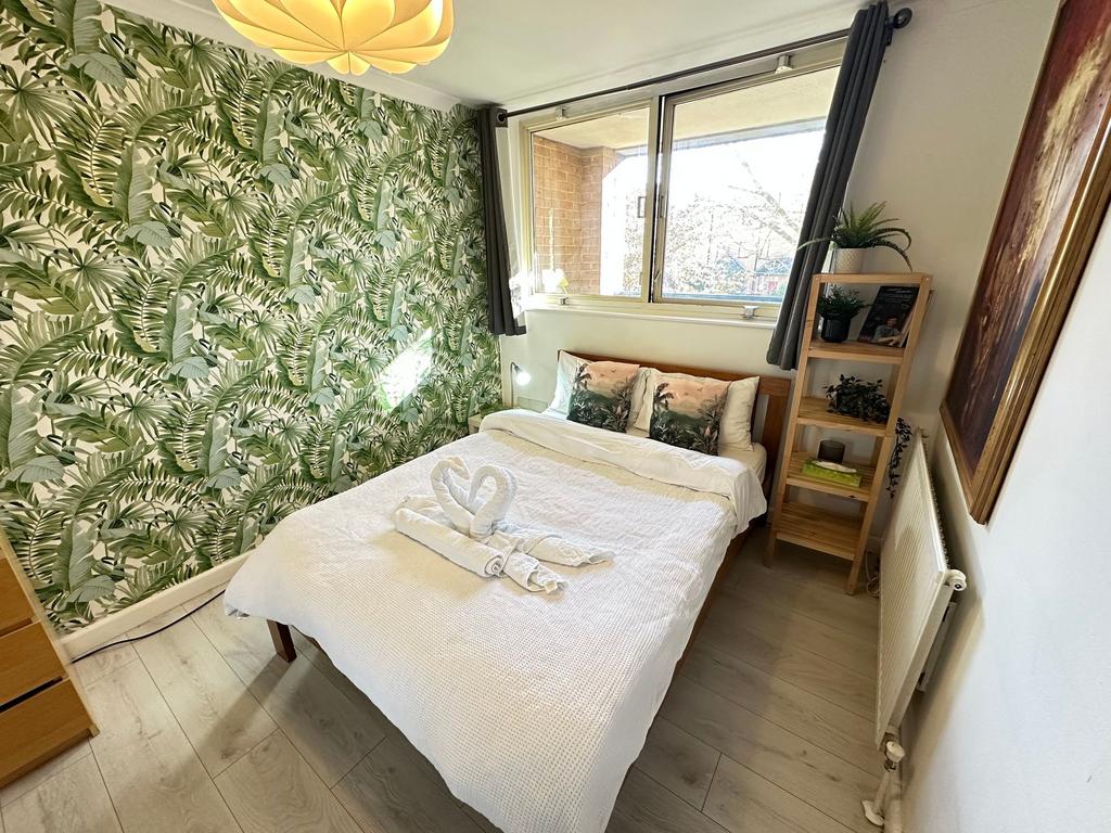 A cozy double bedroom featuring a stylish tropi...