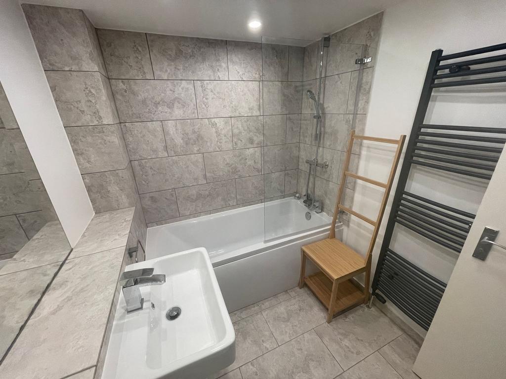 Bright and modern bathroom suite featuring a cl...