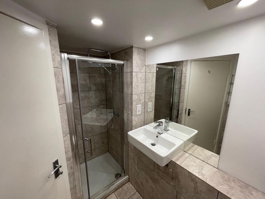 A modern bathroom featuring a clean glass showe...