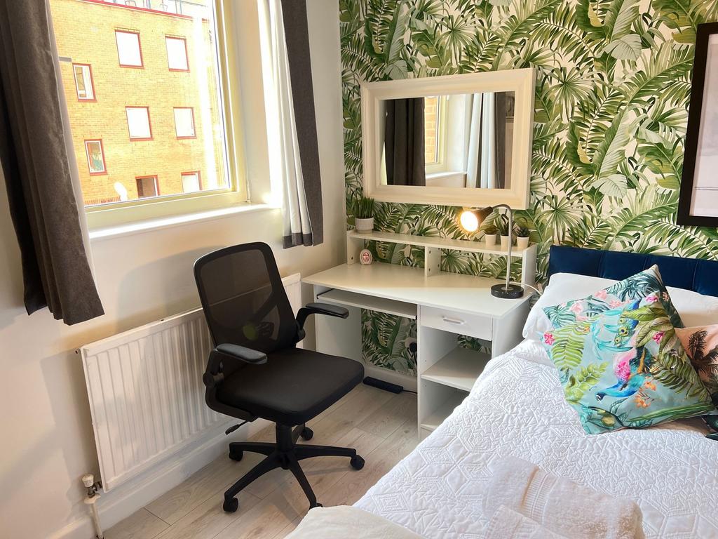 A cozy single bedroom featuring a stylish tropi...