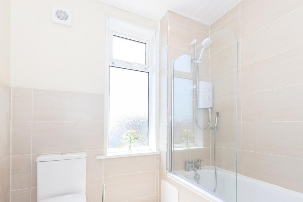 This spacious bathroom suite features a modern ...