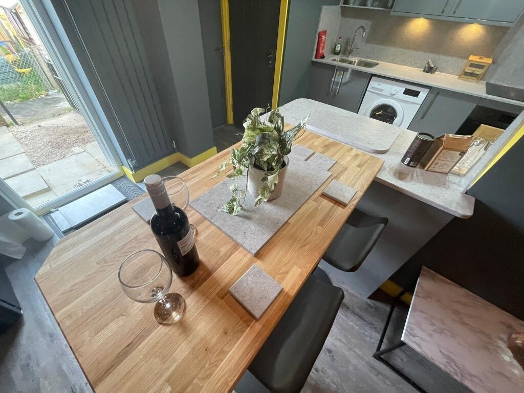 Modern kitchen area featuring a wooden dining t...