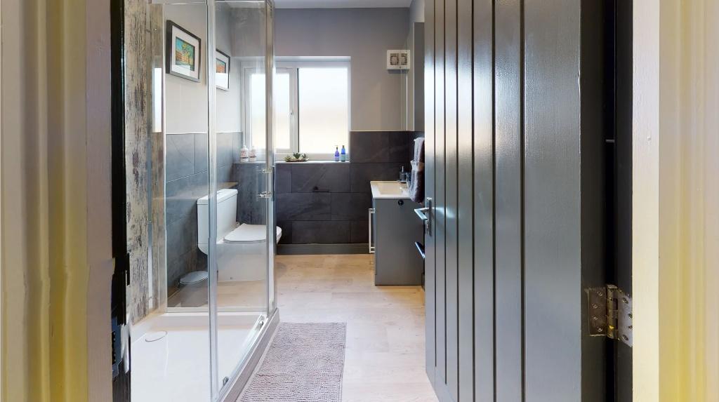A modern bathroom featuring a spacious shower e...