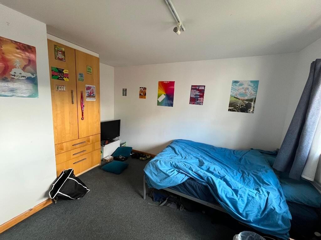 A cozy single bedroom featuring a comfortable b...