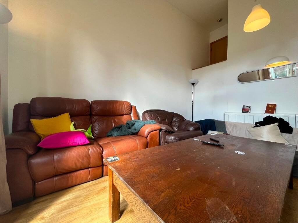 A cozy living room featuring a brown leather so...
