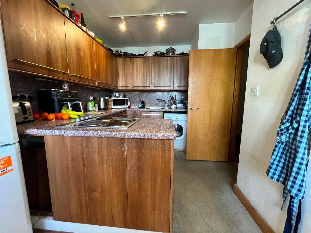 Bright kitchen featuring wooden cabinetry and a...