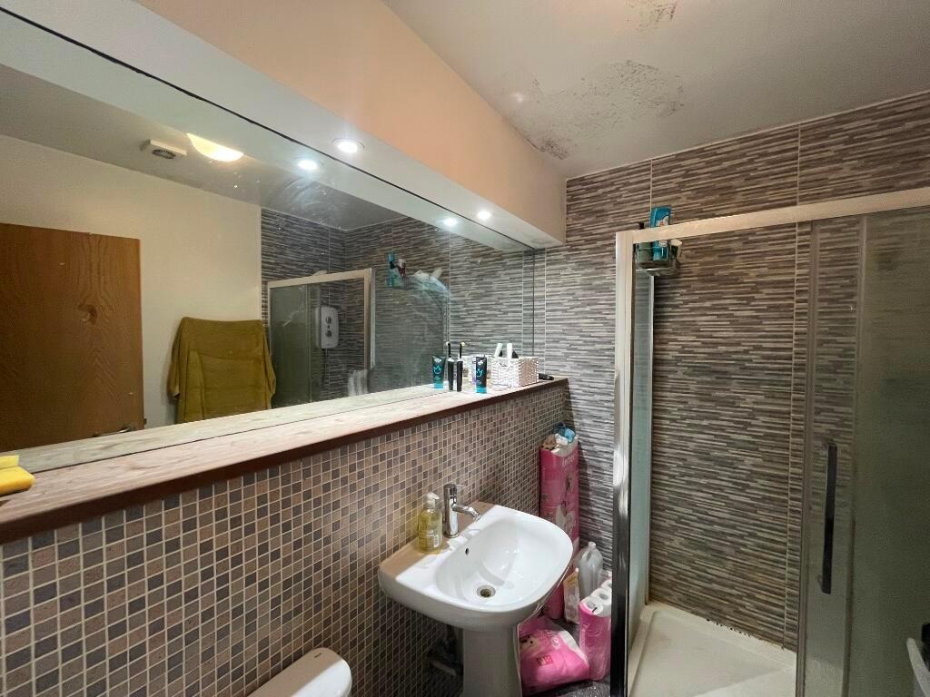 A modern bathroom featuring a glass-enclosed sh...