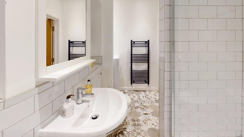 A clean and modern bathroom featuring white til...
