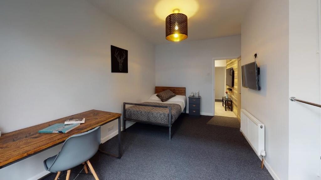 A neat and modern single bedroom featuring a co...
