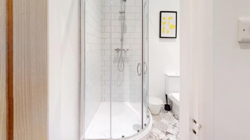 Modern bathroom featuring a curved glass shower...