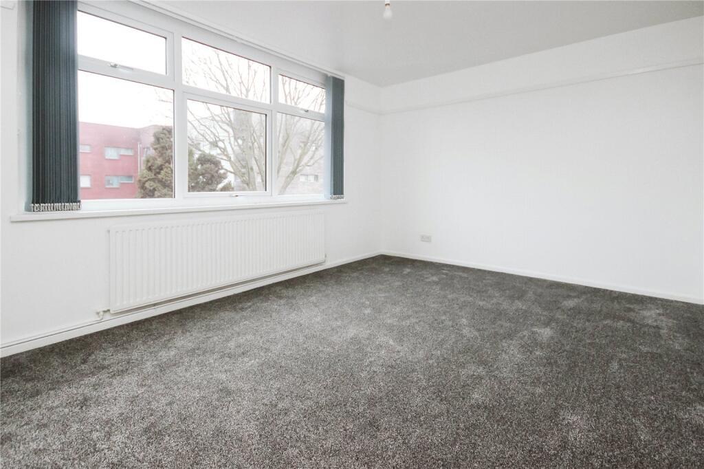 Bright and spacious bedroom featuring a large w...