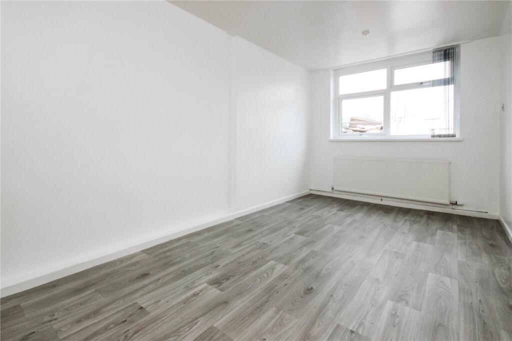 A bright and clean single bedroom featuring mod...