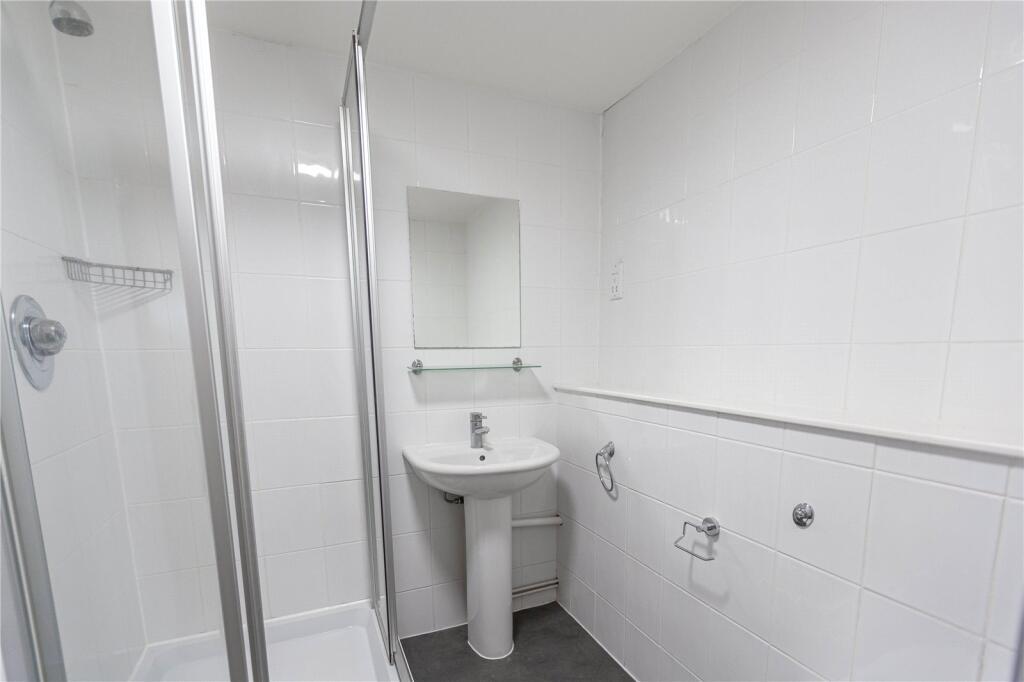 A clean and bright bathroom featuring a walk-in...
